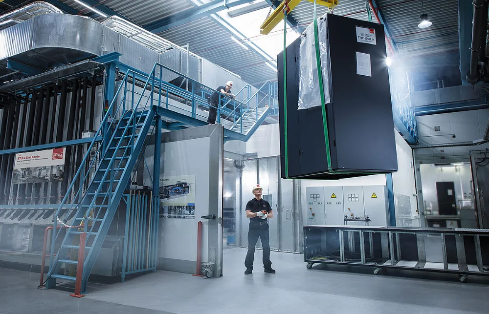 STULZ technician lowering cooling equipment